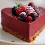 No-bake red velvet heart cheesecake with smooth cream cheese filling and speculoos cookie base, topped with fresh berries